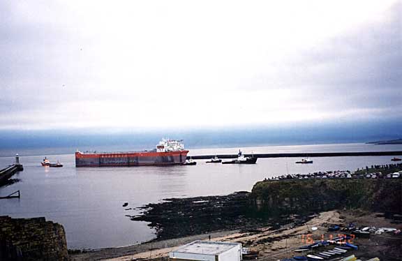 The huge Bonga a combined oil and gas floating production platform is towed on the river Tyne by the hands of the mighty small.