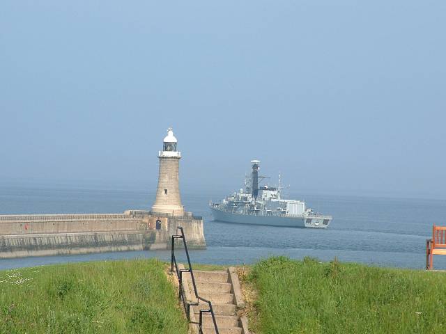 Royal Naval frigate HMS Argyll sailing by the Tynemouth lighthouse and into the open sea.
